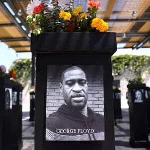 A photograph of George Floyd (C) is displayed along with other photographs at the Say Their Names memorial exhibit at Martin Luther King Jr. Promenade on July 20